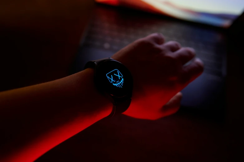 a person wearing a black illuminated watch sitting