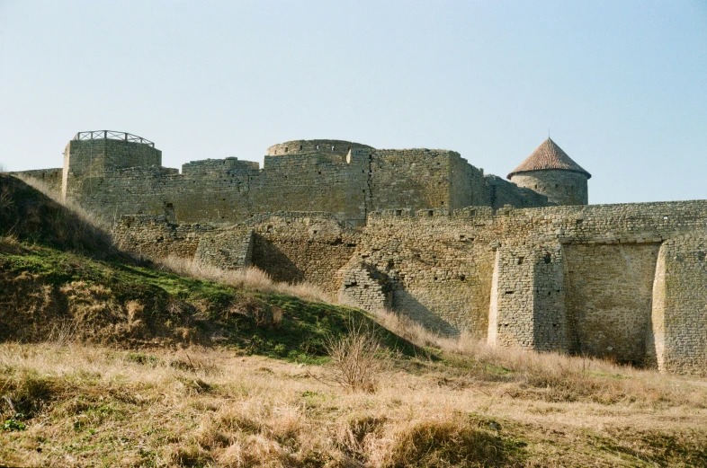 a castle sitting on top of a grass covered hillside