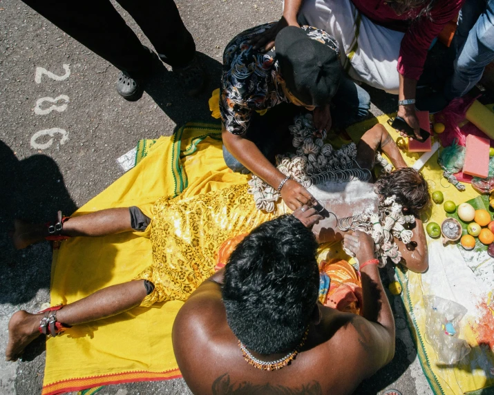 people sitting around and eating while one woman stands at the ground