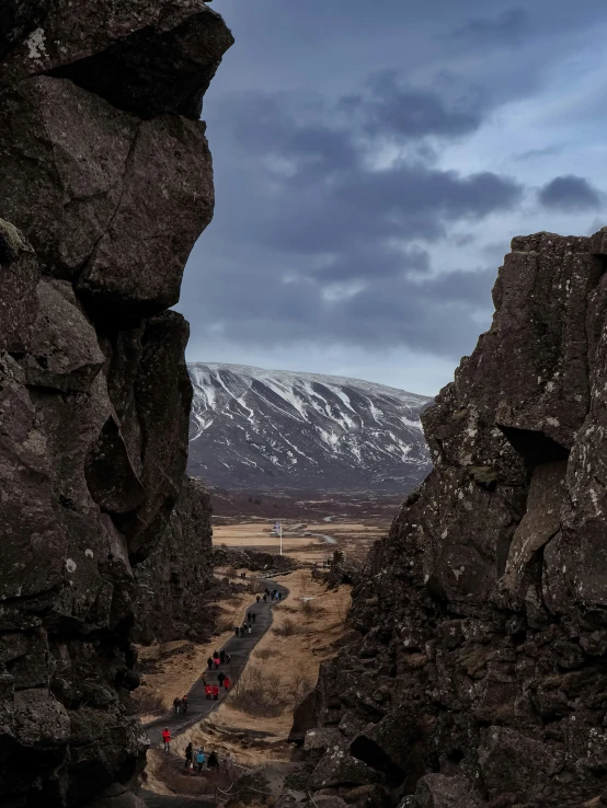 people climbing up a mountain pass as the sun sets