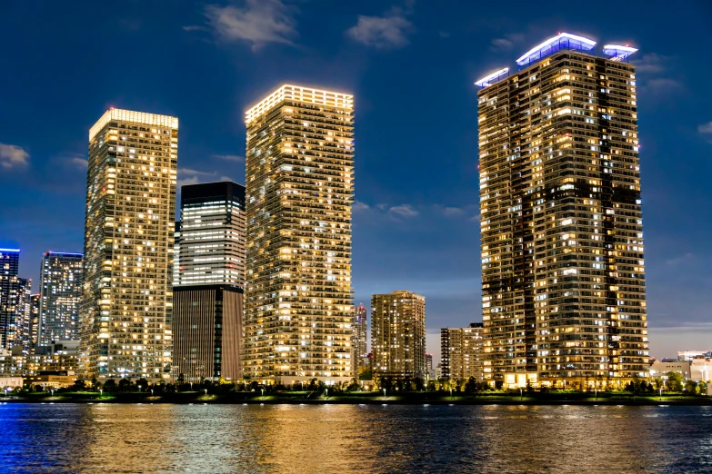 skyscrs are lit up on the waters at night