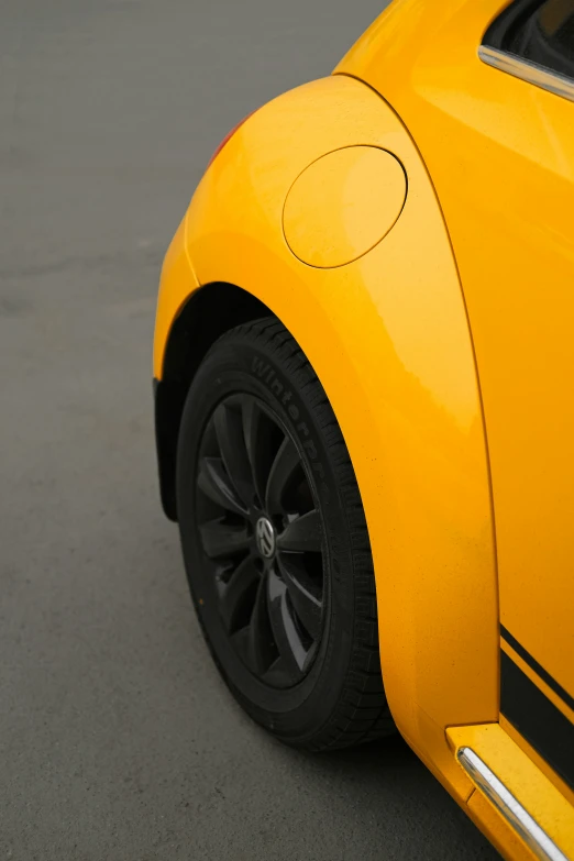 a yellow car is parked outside near asphalt