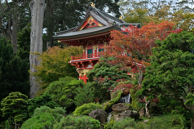 the chinese building is in a beautiful garden setting