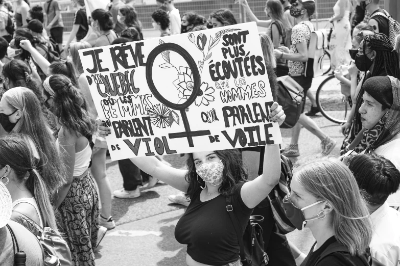 women hold a protest sign that reads, fight against men and women on the outside