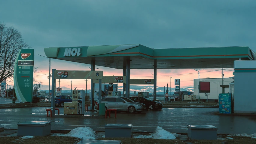 an empty gas station has cars parked by it