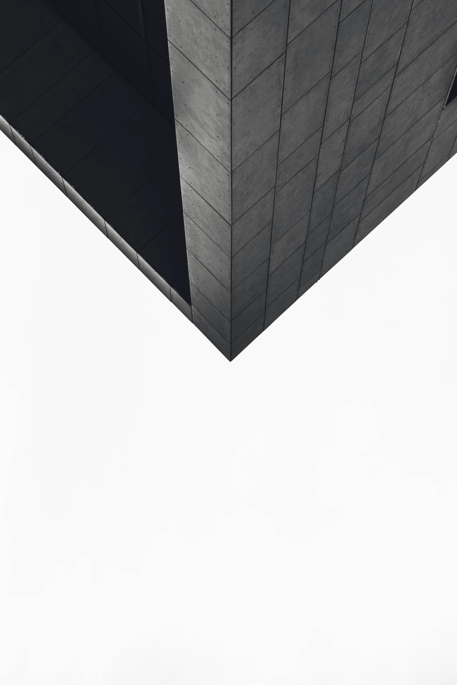 a plane flies through a grey square near a building