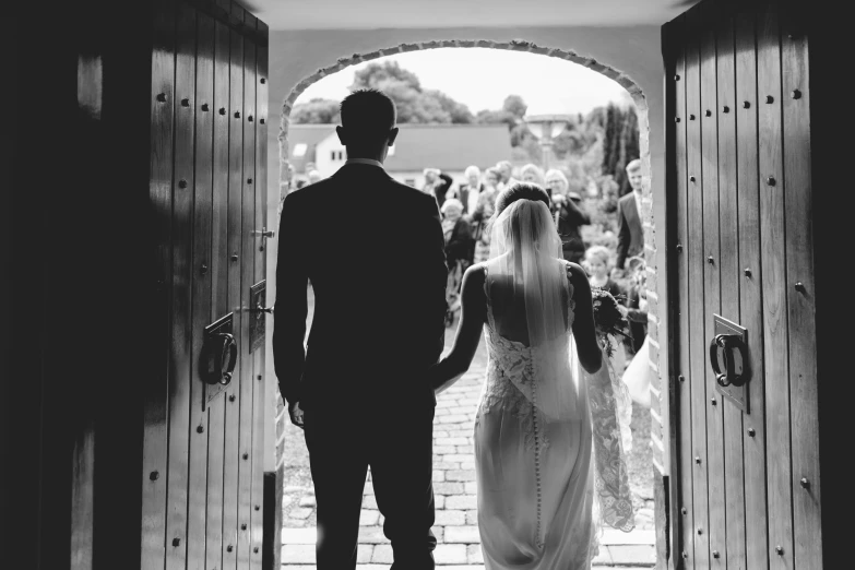 the bride and groom are holding hands as they enter the church