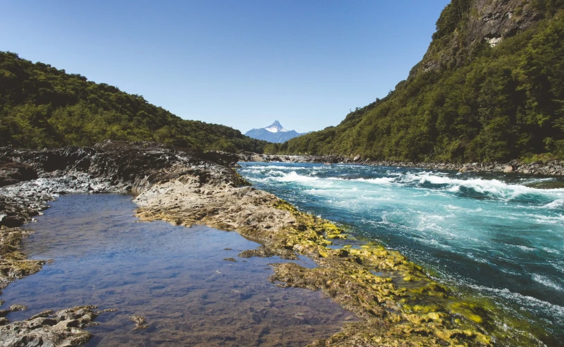 blue water flowing between two large mountains with low waves