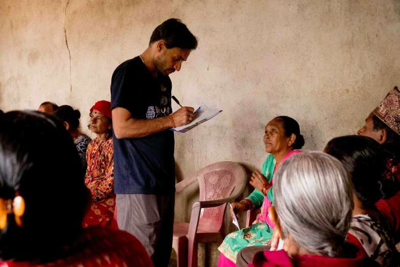 the man is reading while speaking to people