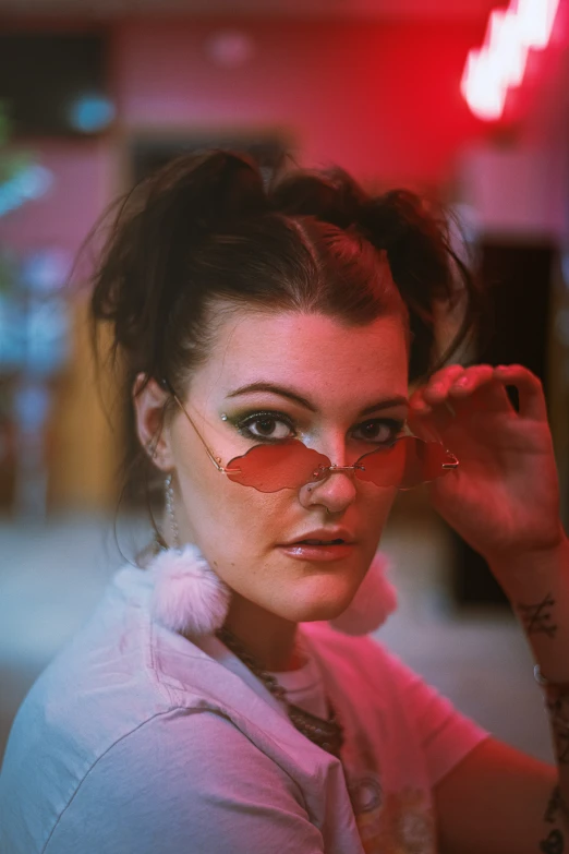 a young woman in glasses with the neon colored background