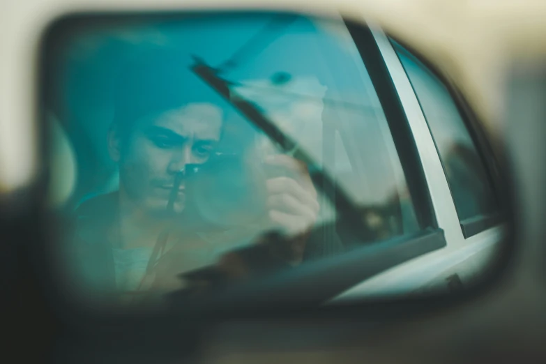 a woman looking into a rear view mirror,