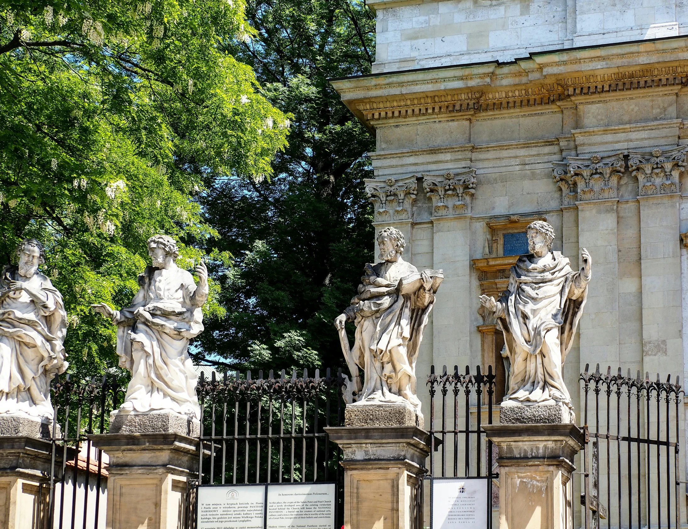 a number of statues near a fence and trees