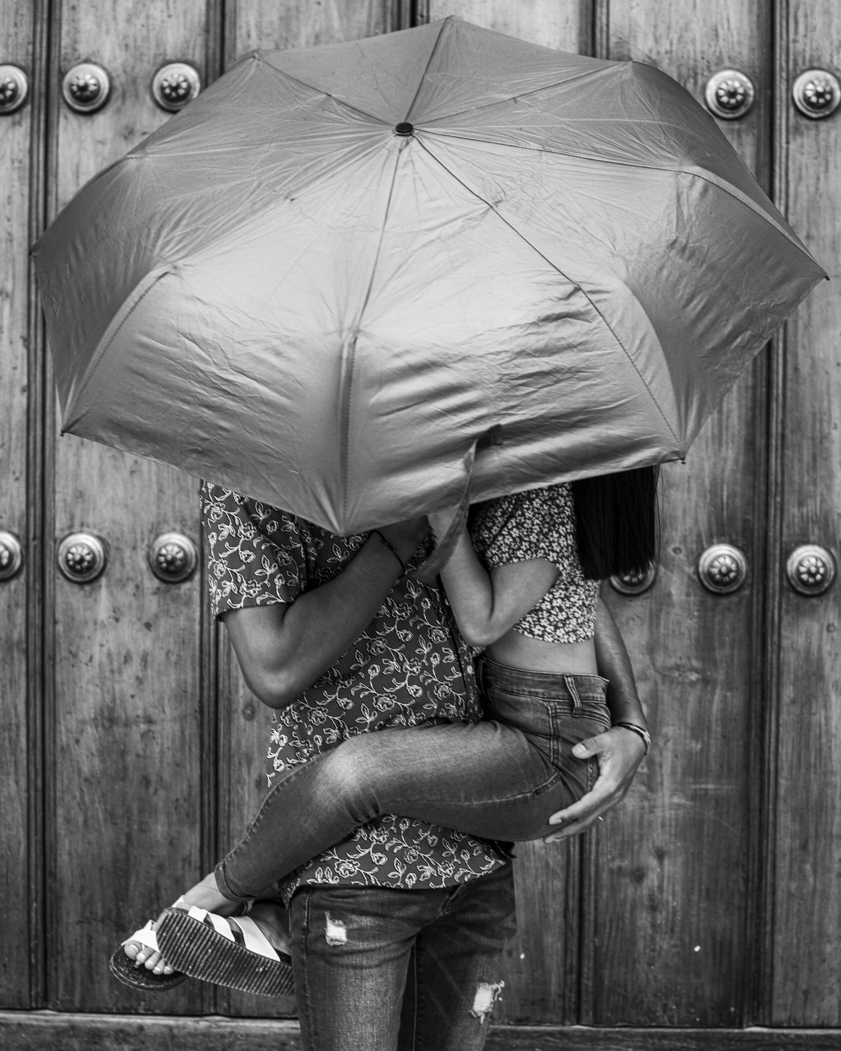 a black and white po of two people emcing with an umbrella