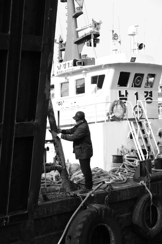 man standing on back of boat and fishing equipment