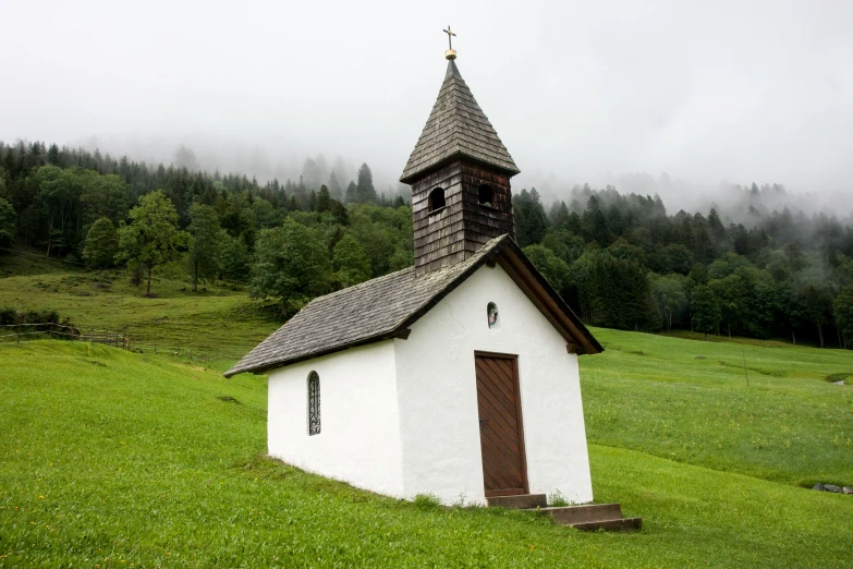 a small church sits on the grass in a field