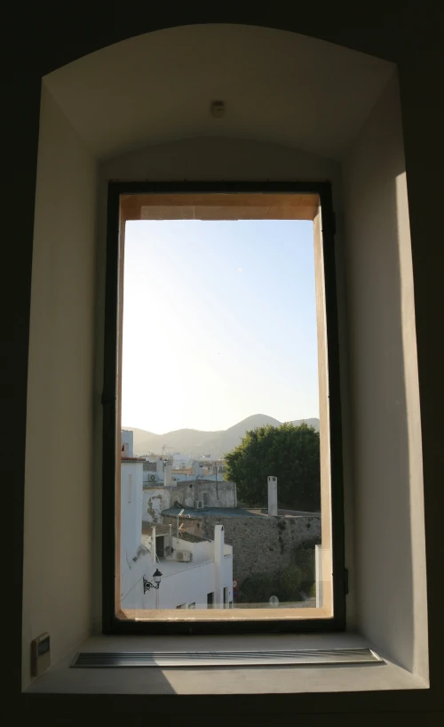 a view out of an open window of a city