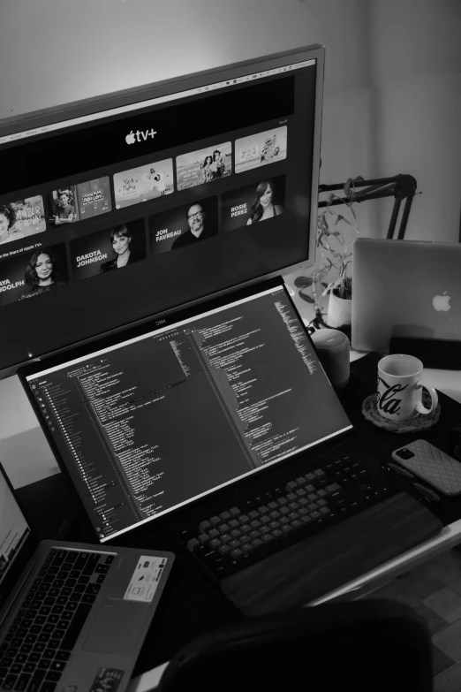 a laptop, phone and monitor are sitting on a desk