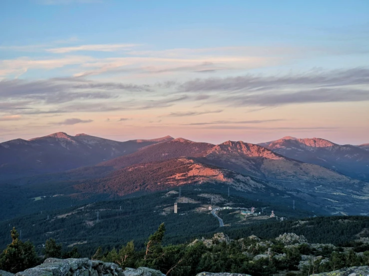 an overlook view of mountains with a building nestled on the top