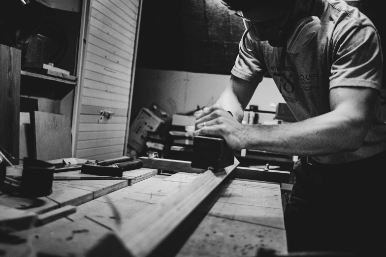 a man working on some wood while looking at his phone