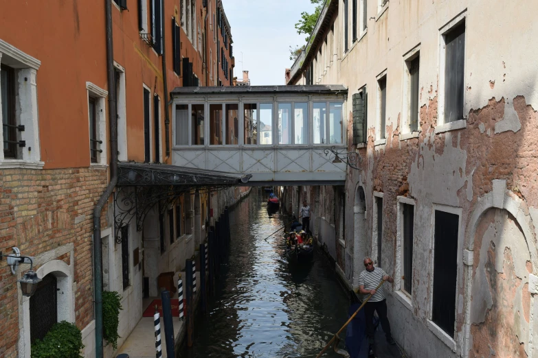 two gondolas are on the side of a canal