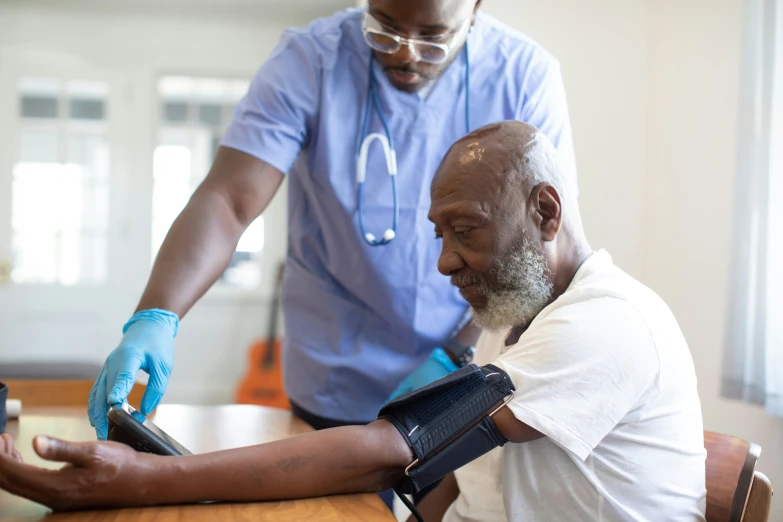 an elderly man sitting in a chair having a medical procedure on his arm