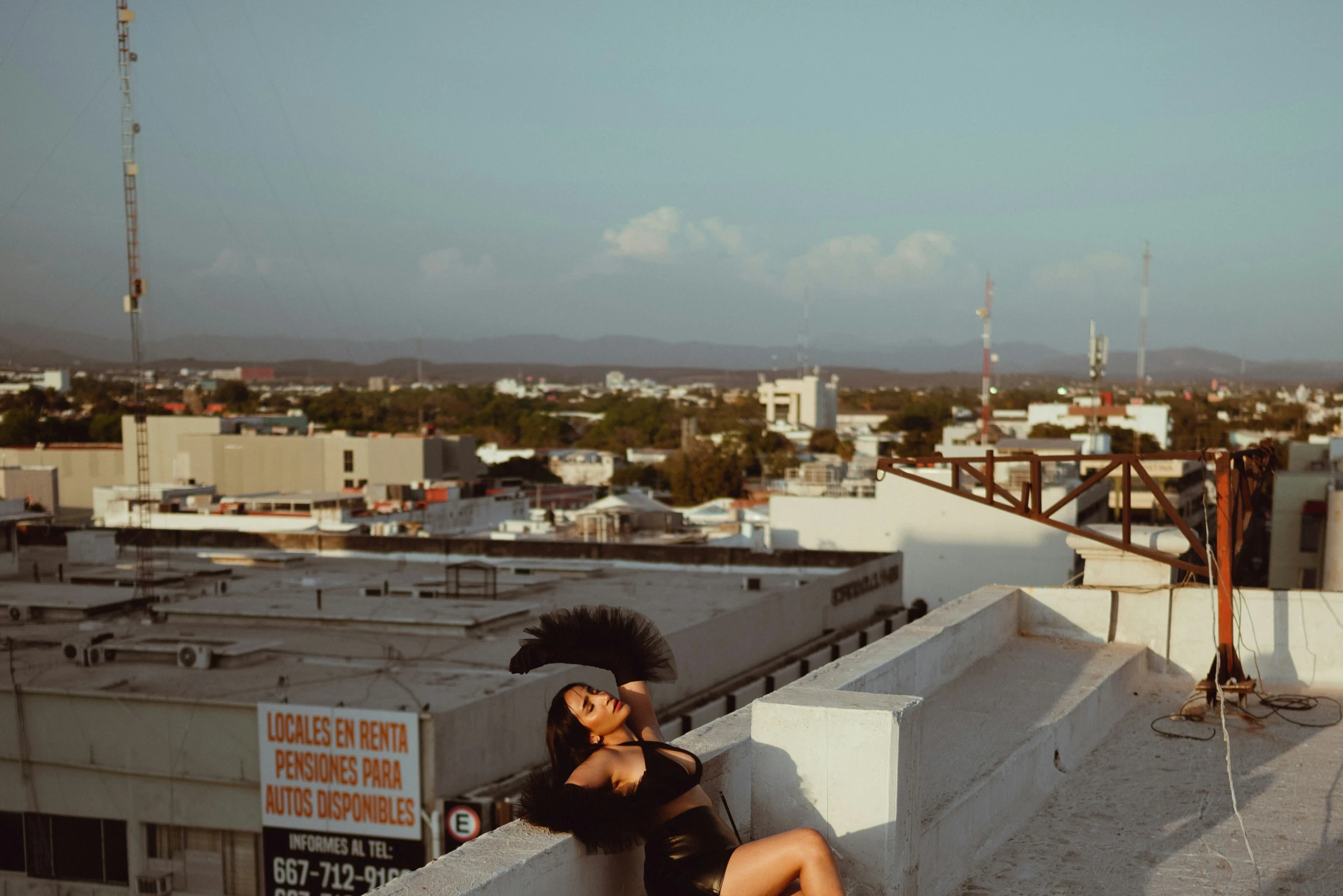 woman sitting on a roof taking a po with her phone