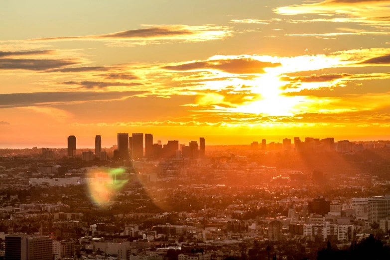 the sun is setting above an urban city