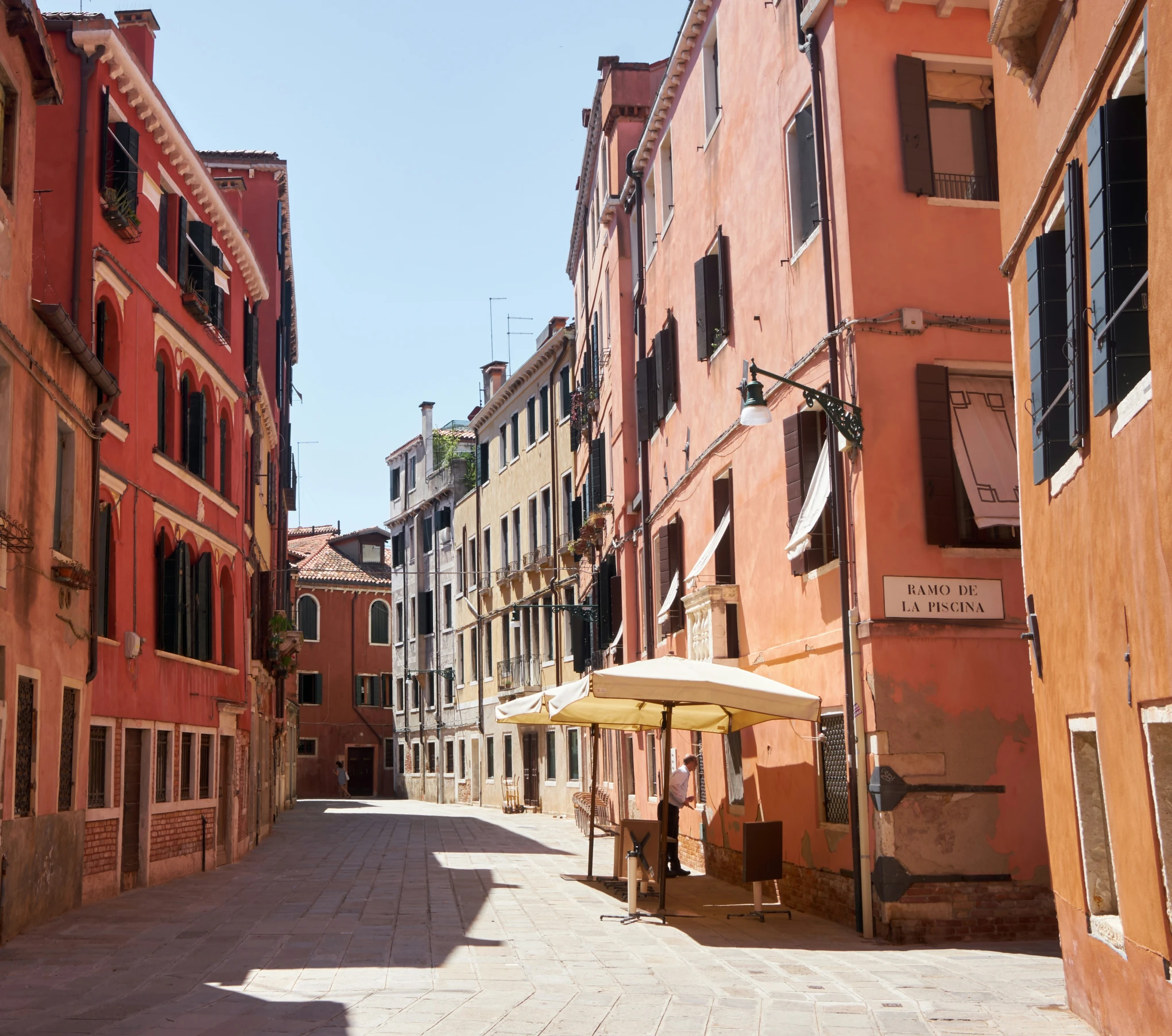 there are several buildings with some umbrellas on the street