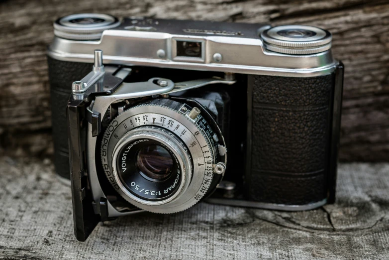 a very old fashioned camera sitting on top of a wooden table