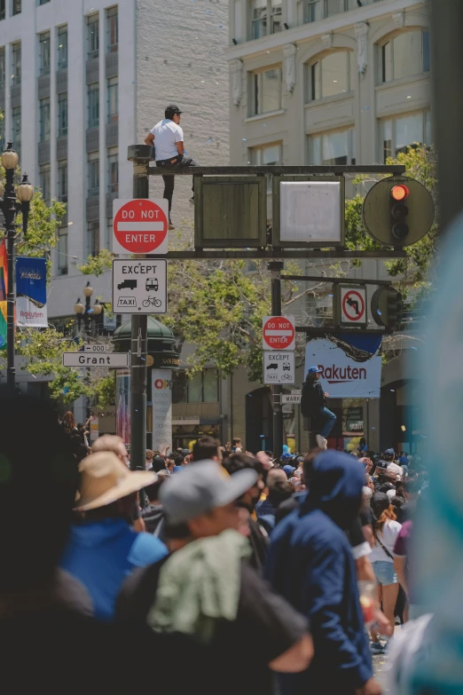 a street intersection with people on top of road signs and buildings in the background