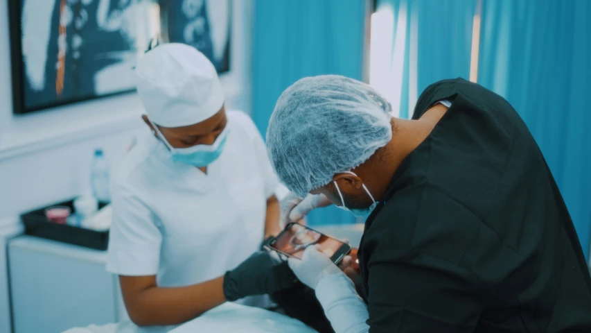 two doctors wearing white coats perform an operation in a hospital