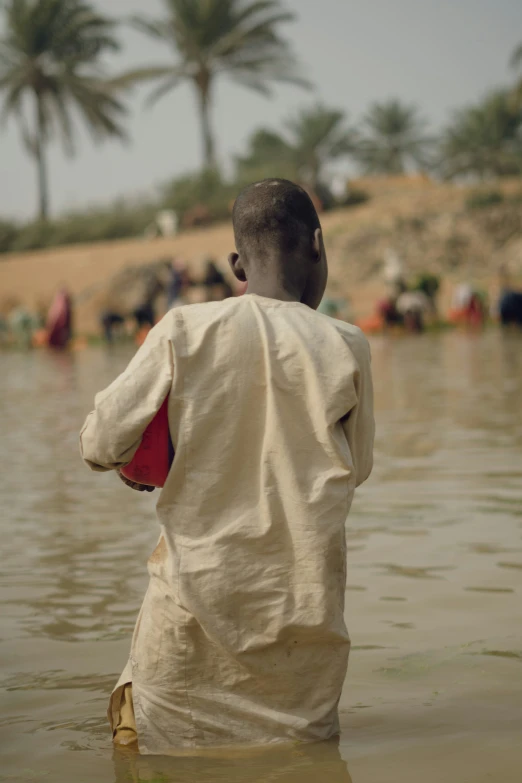 a young man is in the water, looking back