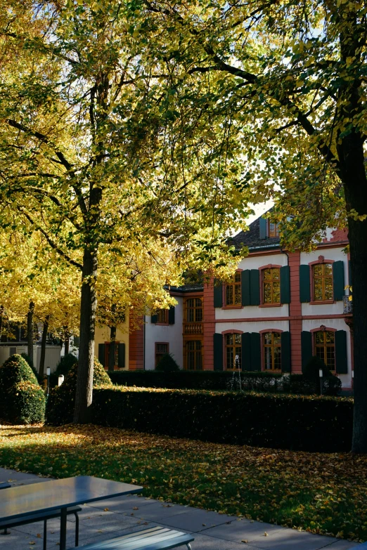 a large red and white mansion surrounded by leafy trees