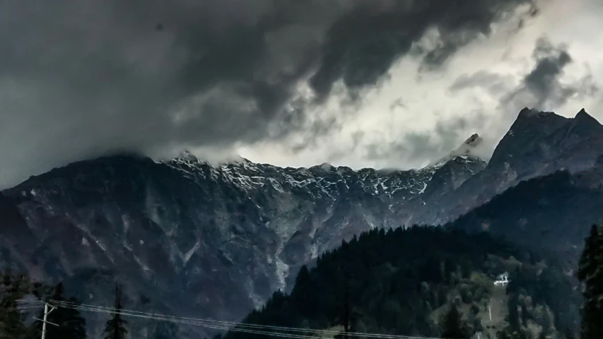 a mountain covered with snow and dark clouds