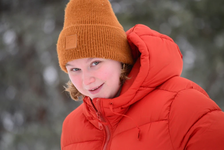 a young woman in the snow with a bright red jacket