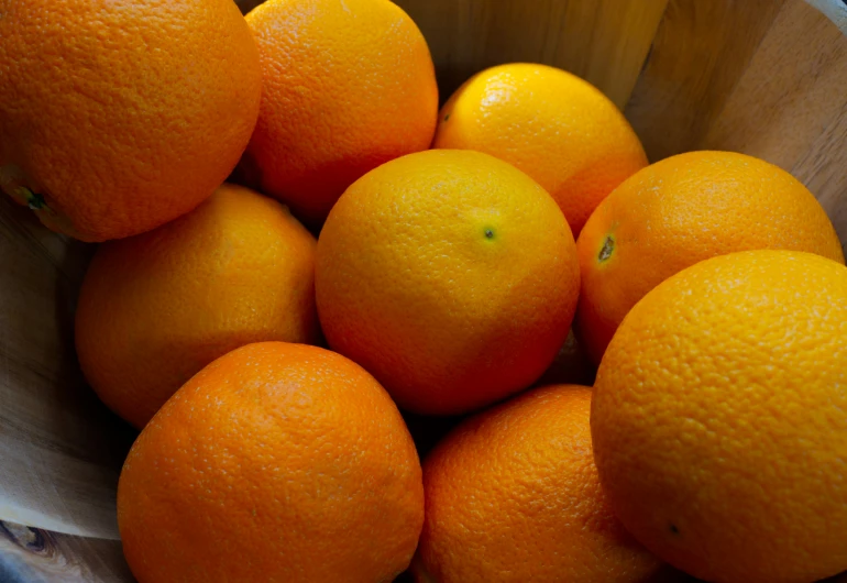 a bowl filled with oranges on top of a table