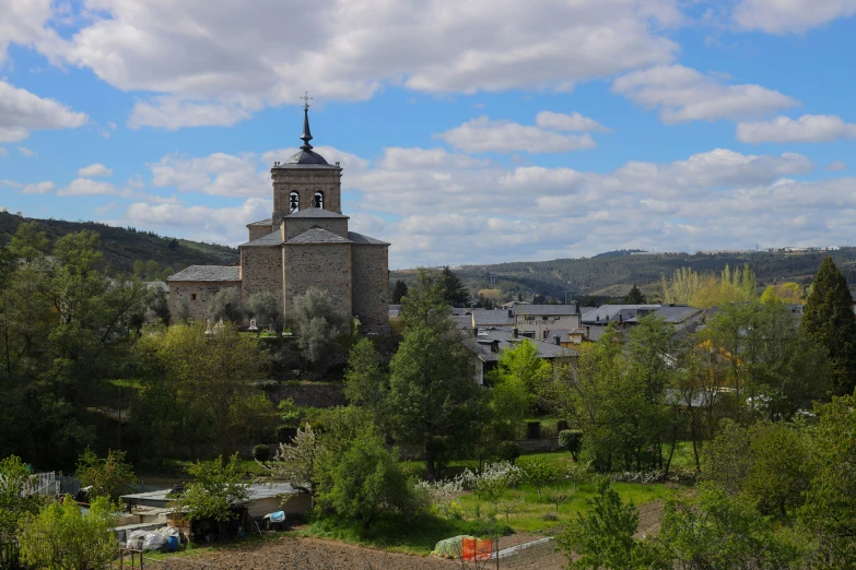 an old church towering over the forest and buildings