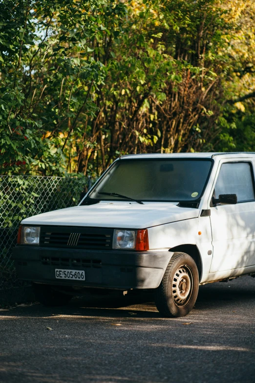 a white truck parked in front of a chain link fence