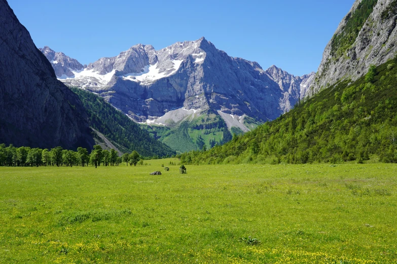 two people hiking through the wilderness surrounded by mountains