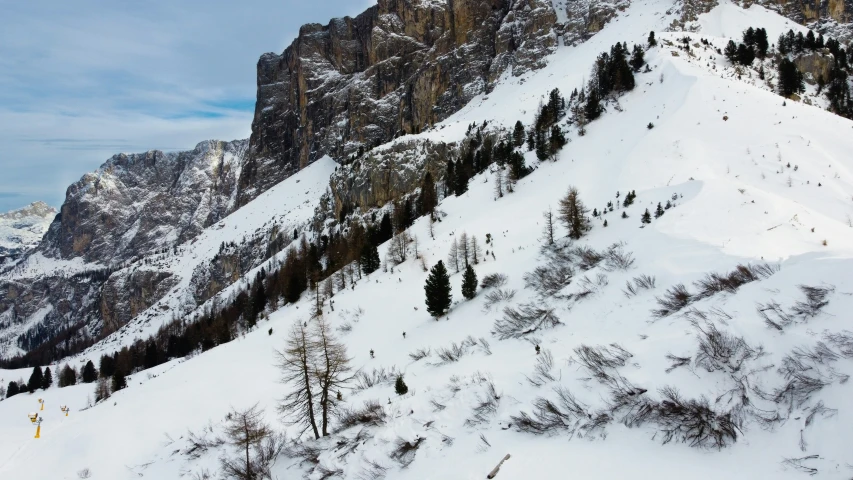 a skier is walking up a snowy mountain side