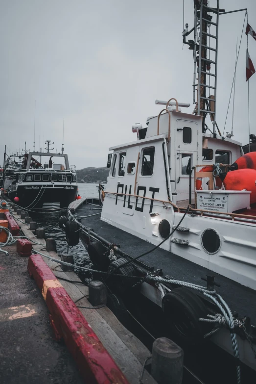 boats are docked next to each other near an orange pole