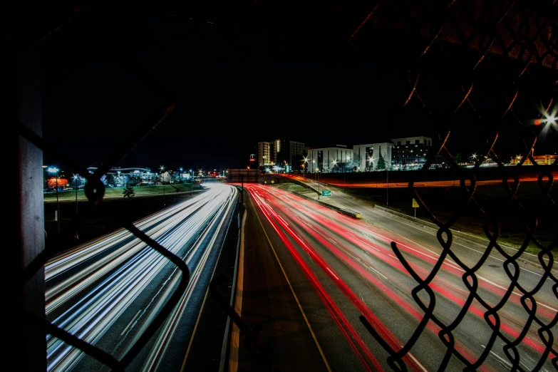 a long exposure of highway and buildings on a dark night
