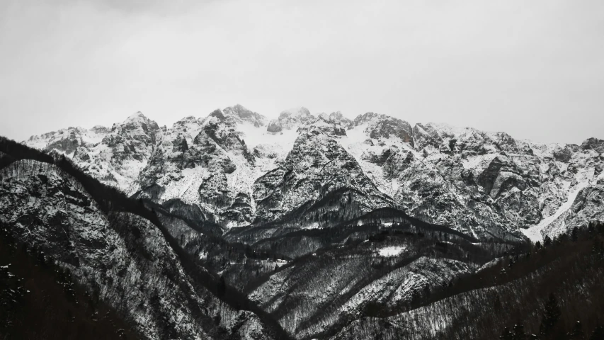 a group of large snow covered mountains in the foreground