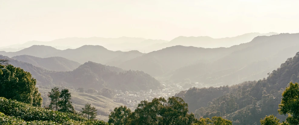 the sun shines brightly on a hazy mountain