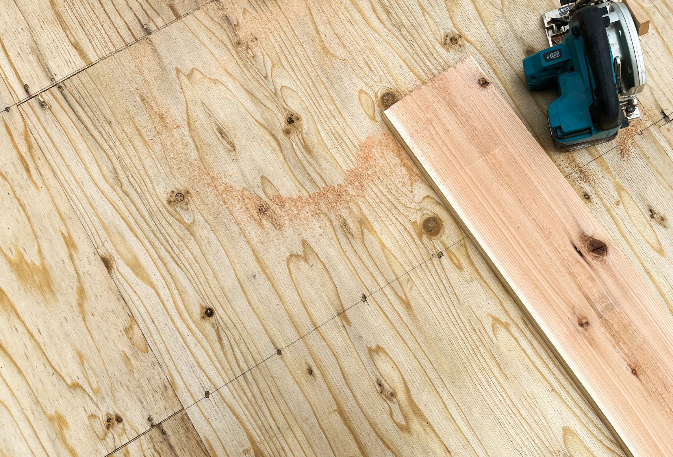 a wooden panel with two screwdrivers and two batteries