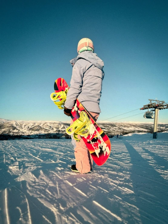 a snowboarder looks over the snowy ground at the horizon