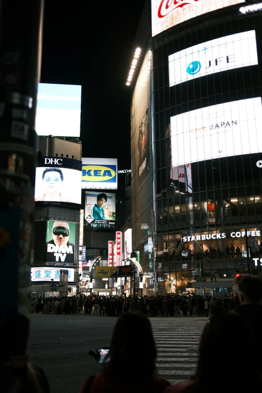 people are crossing the street in front of tall building