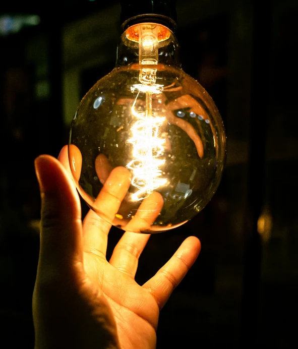 someone holding a shiny glass ball in their hand