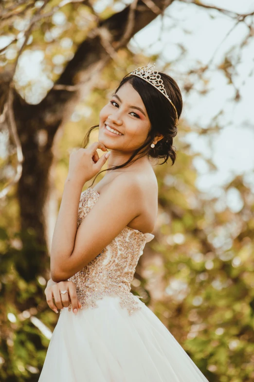 a woman in a white wedding dress standing next to a tree