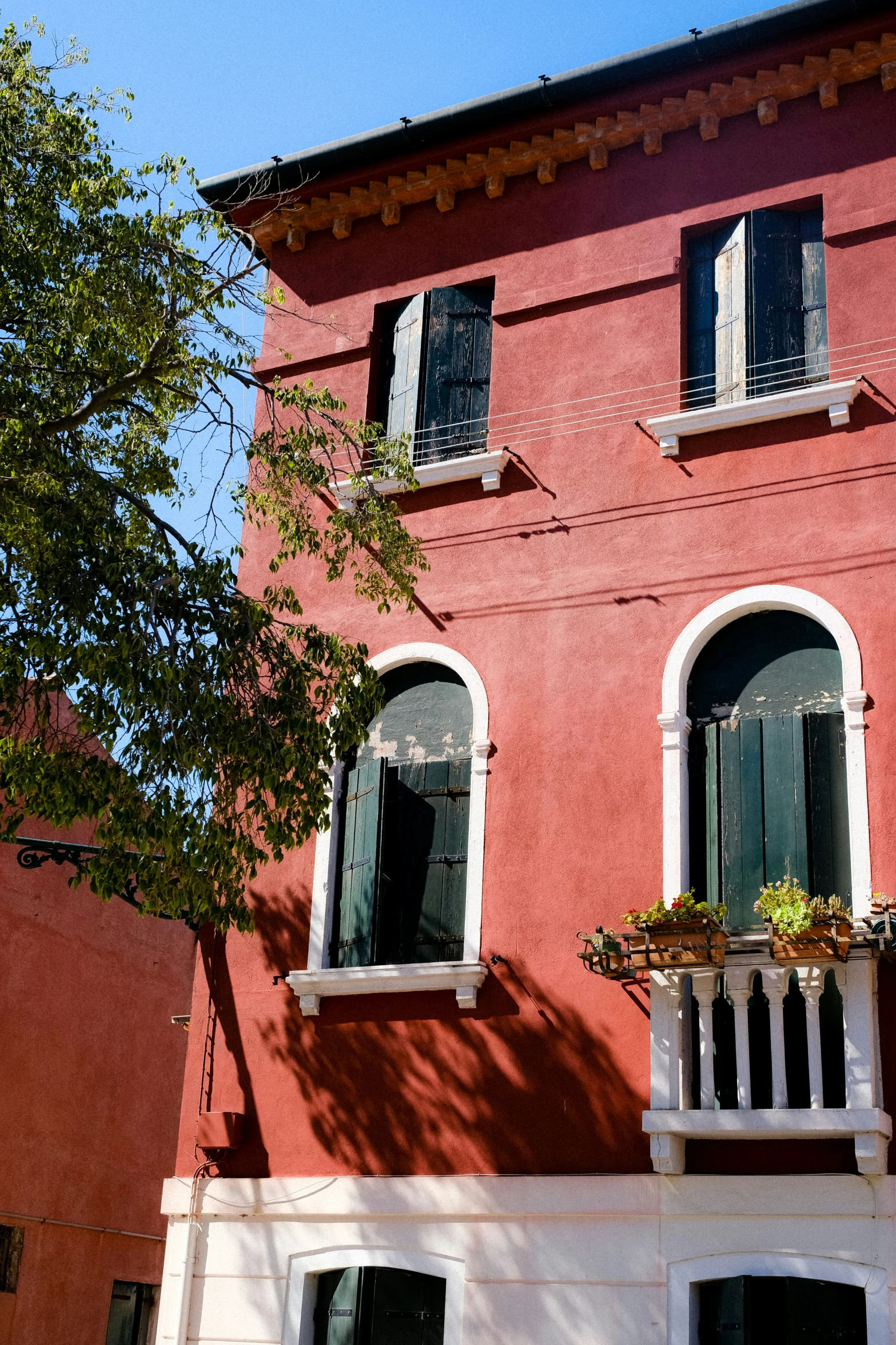 a red building with an elaborate balcony area on each level